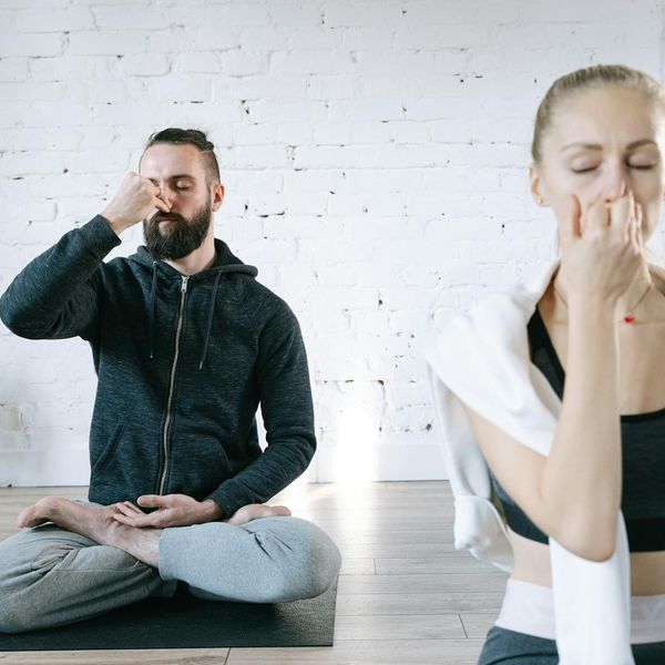 Woman holding a serene yoga pose in a bright, calm room.